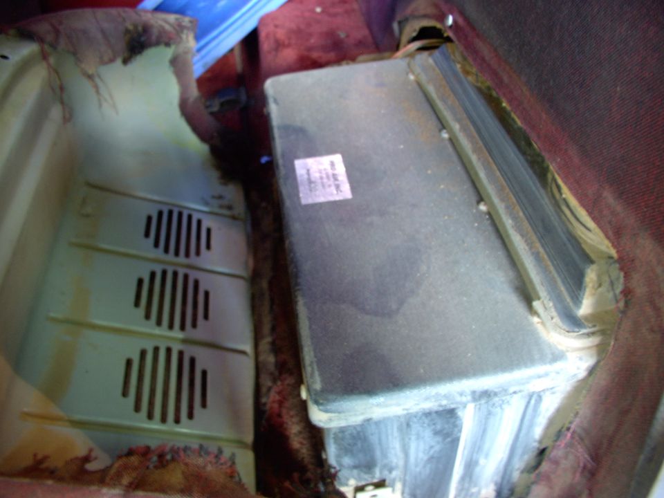 Vehicle AC unit with a sticker on it, next to a vent panel