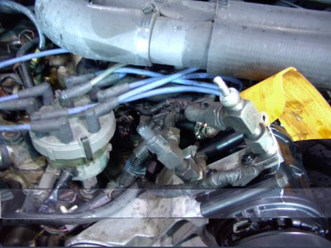1988 Ford C-350 (Centurion Conversions) - Close-up view of engine components including the distributor, spark plug wires, and fuel lines.