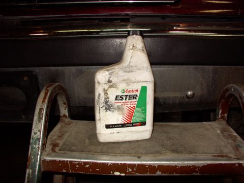 1988 Ford C-350 (Centurion Conversions) - A bottle of Castrol Ester lubricant is placed on a weathered metal step in front of a vehicle's bumper.