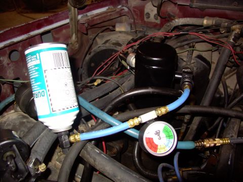 1988 Ford C-350 (Centurion Conversions) - Air conditioning system service with a pressure gauge and refrigerant can attached.