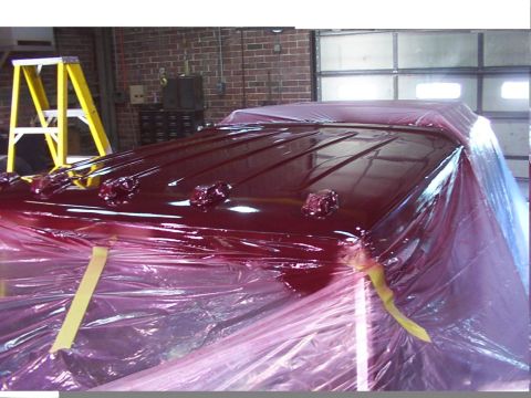 1988 Ford C-350 (Centurion Conversions) - A maroon truck roof is being prepped for paint, covered in protective plastic sheeting.