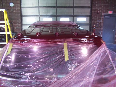 1988 Ford C-350 (Centurion Conversions) - A vehicle's roof, covered in protective plastic wrap, is visible in a workshop setting.