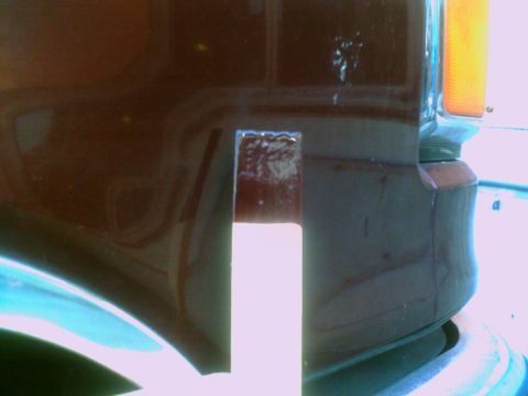1988 Ford C-350 (Centurion Conversions) - Detail shot of a brown vehicle's front corner, showing the turn signal and body panel.