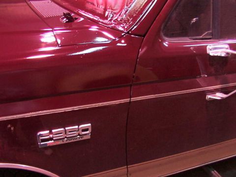 1988 Ford C-350 (Centurion Conversions) - Close-up of a maroon truck's door and hood, showing the F-350 Lariat badging, consistent with a 1988 Ford C-350 (Centurion Conversions).