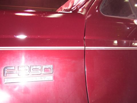 1988 Ford C-350 (Centurion Conversions) - Close-up of a red truck's side panel showing the F-350 emblem.