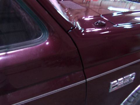 1988 Ford C-350 (Centurion Conversions) - Close-up of a maroon Ford truck's side panel, showing a "350" emblem and chrome trim.
