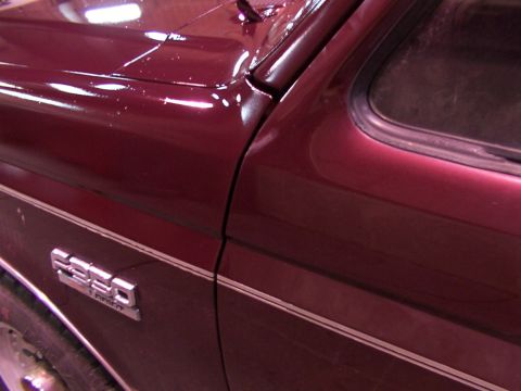 1988 Ford C-350 (Centurion Conversions) - Close-up of a maroon 1988 Ford C-350 (Centurion Conversions) showing the fender badge and body lines.