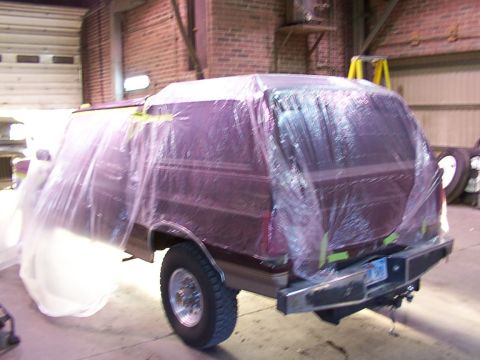 1988 Ford C-350 (Centurion Conversions) - A van is covered in plastic sheeting, preparing for a paint job in a workshop.