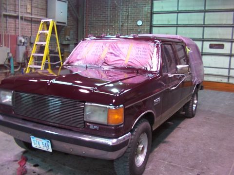 1988 Ford C-350 (Centurion Conversions) - Maroon van with pink plastic covering the windows, displaying text that reads "We Take Pride In Your Vehicle".