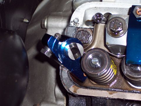 1963 Ford Galaxie - Close-up view of a blue aftermarket roller rocker arm assembly within an engine's valve train.