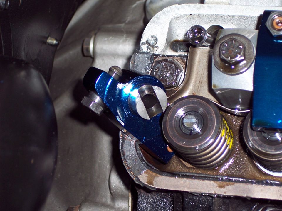 Blue aftermarket roller rocker arm on engine valve train