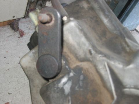 1991 Ford Bronco - A close-up view of a mechanical linkage on a vehicle's transmission housing.
