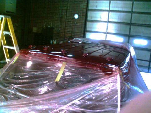 1988 Ford C-350 (Centurion Conversions) - The roof of a vehicle, possibly a van or truck, is covered in plastic wrap and appears to be undergoing a paint job.