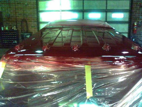 1988 Ford C-350 (Centurion Conversions) - A vehicle's roof is covered in plastic sheeting and tape, possibly during a paint job.