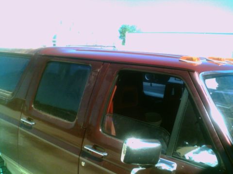 1988 Ford C-350 (Centurion Conversions) - Side view of a red pickup truck cab, likely from the 1980s, with tinted windows and roof marker lights.