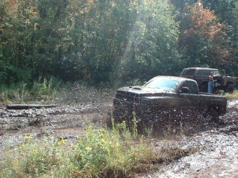 1978 Ford Bronco - Off-road vehicles are stuck in deep mud during an outdoor excursion.