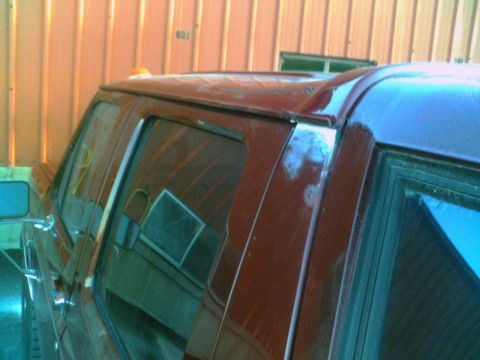1988 Ford C-350 (Centurion Conversions) - Close-up of a red pickup truck's cab, focusing on the door and roof area.