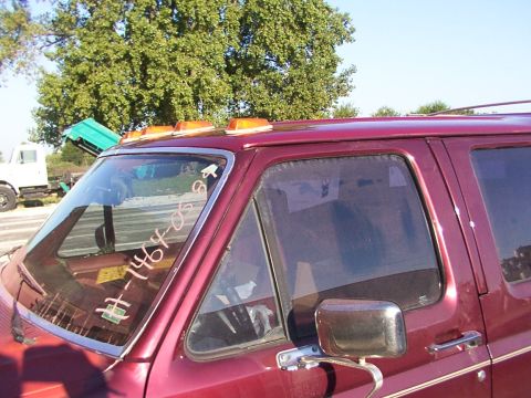 1988 Ford C-350 (Centurion Conversions) - A red van with amber roof lights is parked near a white truck with a green dump bed.