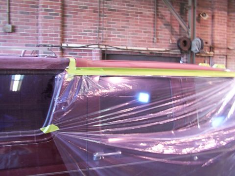 1988 Ford C-350 (Centurion Conversions) - A van's side is covered in plastic sheeting and tape, suggesting it is undergoing bodywork or painting.