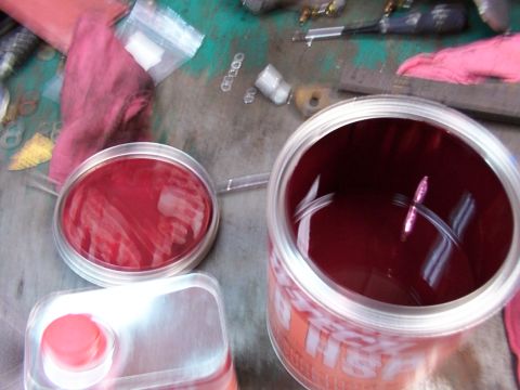 1988 Ford C-350 (Centurion Conversions) - Open cans of red paint and a sealed container sit on a surface with various tools and rags.