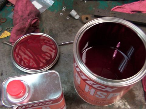 1988 Ford C-350 (Centurion Conversions) - An open can of red grease sits next to its lid and a smaller container of the same substance.