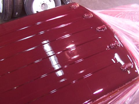 1988 Ford C-350 (Centurion Conversions) - Close-up of a red roof panel, possibly for a van or RV, with clearance lights.