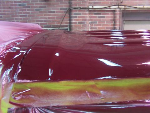 1988 Ford C-350 (Centurion Conversions) - The shiny, dark red roof of a vehicle is covered in protective sheeting and tape, awaiting a fresh coat of paint.