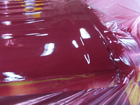 1988 Ford C-350 (Centurion Conversions) - The freshly painted surface of a vehicle's roof is covered with protective plastic sheeting.