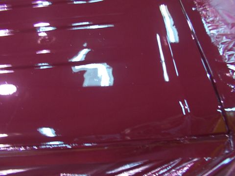1988 Ford C-350 (Centurion Conversions) - Close-up of a maroon car roof, showing reflections and protective plastic sheeting.