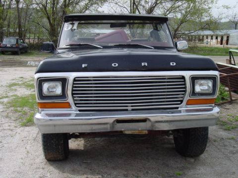 1979 Ford Bronco - A black 1978 Ford Bronco is shown from the front, with its chrome bumper and horizontal grille prominent.