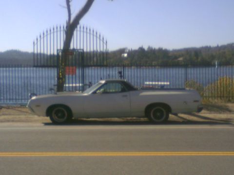 1972 Ford Ranchero - Side view of a 1972 Ford Ranchero parked next to a fence with a lake in the background.