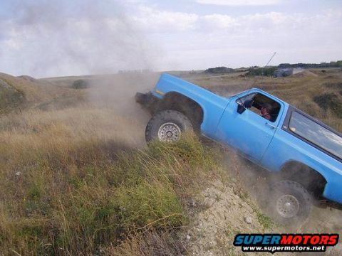 1989 Chevrolet Blazer - A blue 1989 Chevrolet Blazer navigates a dusty off-road trail, kicking up dirt as it goes.