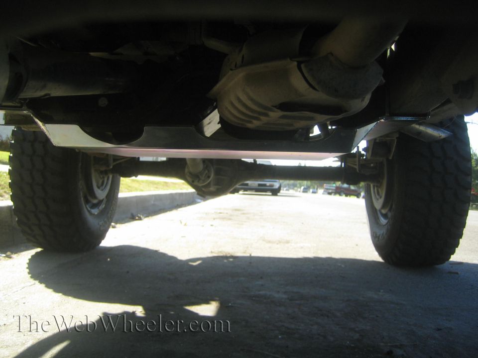 Underbody view of a vehicle showing a skid plate and suspension components