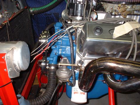 1969 Ford Mustang - Close-up view of an engine bay a blue engine block, chrome valve covers, and exhaust headers.