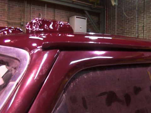1988 Ford C-350 (Centurion Conversions) - The roof of a vehicle shows a custom modification with peeling paint or wrap, obscuring its original details.