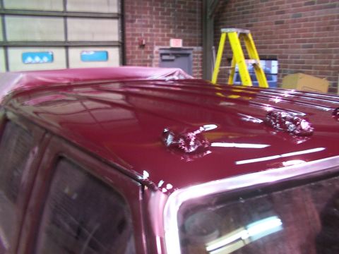 1988 Ford C-350 (Centurion Conversions) - The maroon roof of a vehicle shows three cab lights and chrome trim, possibly after a paint job.