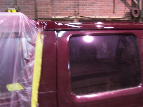1988 Ford C-350 (Centurion Conversions) - A vehicle is being prepped for painting, with plastic sheeting and tape covering parts of the body.