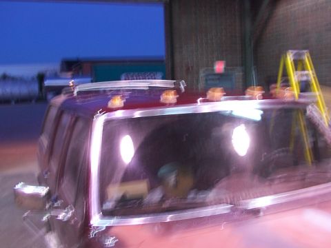 1988 Ford C-350 (Centurion Conversions) - A blurry photo shows the top of a red truck cab with amber marker lights on the roof.