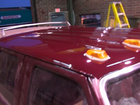1988 Ford C-350 (Centurion Conversions) - The roof of a red pickup truck is visible, equipped with amber clearance lights and a chrome roof rack.