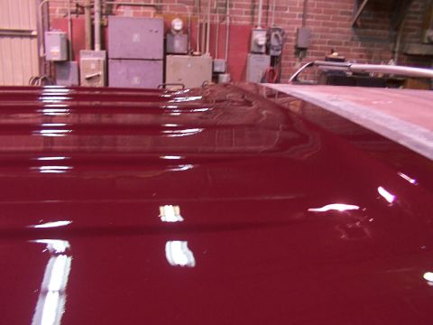 1988 Ford C-350 (Centurion Conversions) - Close-up of a shiny red vehicle roof with a silver rack, taken from a high angle.