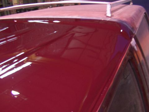 1988 Ford C-350 (Centurion Conversions) - Close-up of a red vehicle's roof and roof rack, showing reflections on the paint surface.