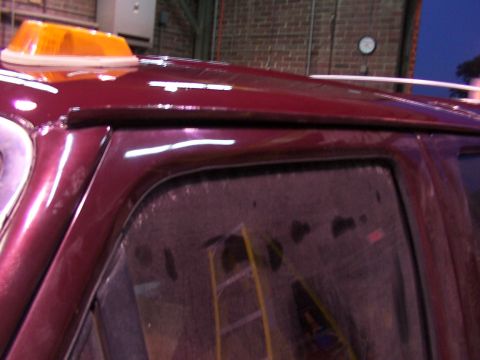 1988 Ford C-350 (Centurion Conversions) - Close-up of a burgundy vehicle's side, an orange light mounted on the roof.