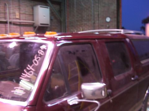 1988 Ford C-350 (Centurion Conversions) - Maroon SUV with roof lights and writing on the windshield.