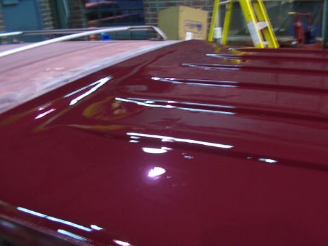 1988 Ford C-350 (Centurion Conversions) - The glossy maroon roof of a vehicle displays horizontal ridges and a patch of red primer, indicating recent work.