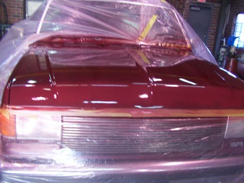 1988 Ford C-350 (Centurion Conversions) - Car hood and front end are covered in plastic sheeting during a paint job.