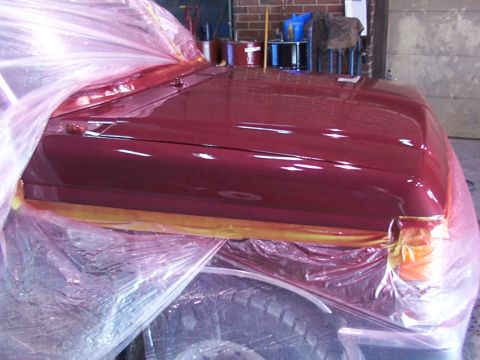 1988 Ford C-350 (Centurion Conversions) - Vehicle bodywork covered in plastic sheeting during a paint job.