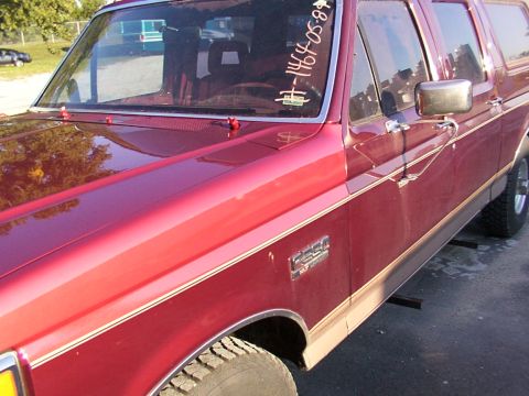1988 Ford C-350 (Centurion Conversions) - A red Ford F-Series truck is shown from the front quarter angle, with a close-up on the fender and door panel.