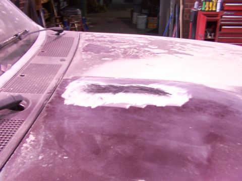 1988 Ford C-350 (Centurion Conversions) - A section of a vehicle's hood is shown with body filler applied, indicating repair work is in progress.