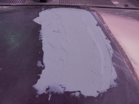 1988 Ford C-350 (Centurion Conversions) - Body filler covers a section of a vehicle's hood, indicating repair work.