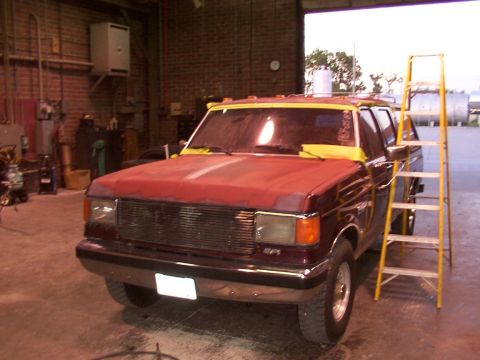 1988 Ford C-350 (Centurion Conversions) - Front view of a maroon Ford F-Series truck undergoing bodywork in a garage.